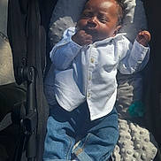 Hunter is registered to the contest to win money with this photo: baby, infant, stroller, clothing, white_shirt, blue_jeans, socks, sleeping, sunlight, hand, face, cute, child, outdoor, blanket, comfort, resting, portrait, casual, relaxation