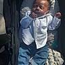 baby, infant, stroller, clothing, white_shirt, blue_jeans, socks, sleeping, sunlight, hand, face, cute, child, outdoor, blanket, comfort, resting, portrait, casual, relaxation