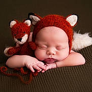 Elias joined the competition — help win amazing prizes! baby, sleeping, fox_hat, plush_toy, knitted, brown_blanket, cute, infant, portrait, cozy, soft_texture, child, adorable, peaceful, resting, animal_ears, newborn, hands, face, closeup