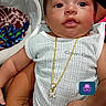 baby, infant, child, person, calvin_klein, gold_chain, clothing, swing, blanket, hand, indoor, cute, portrait, smiling, face, human, expression, holding, colorful, emoji