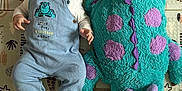 Lyam a rejoint le concours — aidez-le/la à gagner de superbes lots ! baby, blue_clothing, child, colorful, cute, fabric, feet, happy, head, indoor, infant, lying_down, monster, overalls, patterned_mat, playmat, plush_toy, smiling, soft_toy, texture
