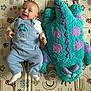 Lyam a rejoint le concours — aidez-le/la à gagner de superbes lots ! baby, child, smiling, overalls, plush_toy, monster, blue_clothing, patterned_mat, indoor, cute, happy, infant, soft_toy, playmat, lying_down, feet, head, fabric, texture, colorful