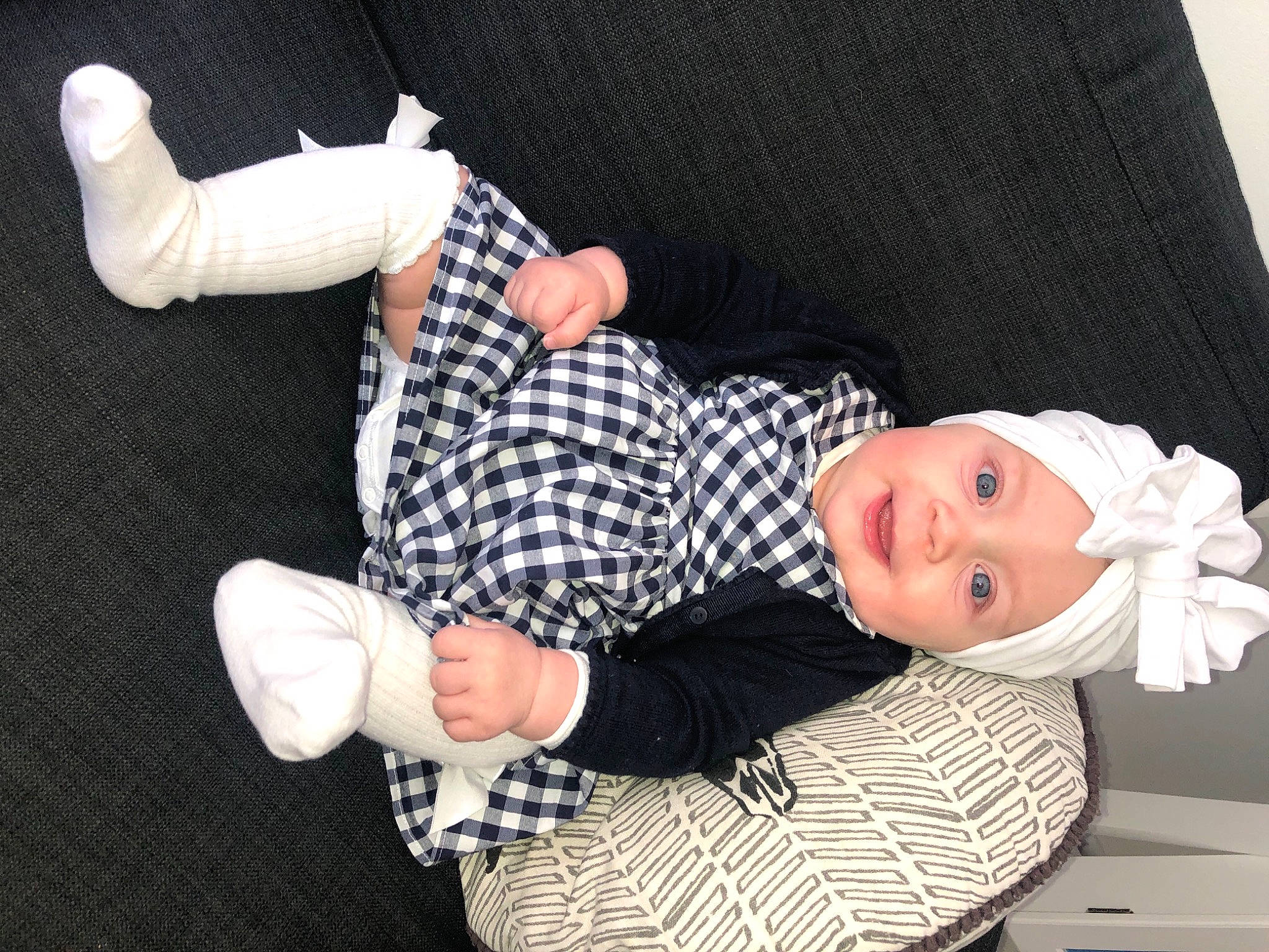 Talia a rejoint le concours — aidez-le/la à gagner de superbes lots ! baby, baby_products, baby_toddler_clothing, black, child, comfort, fashion_accessory, finger, gesture, hand, headwear, nail, pattern, person, sitting, sleeve, smile, sock, thumb, wood