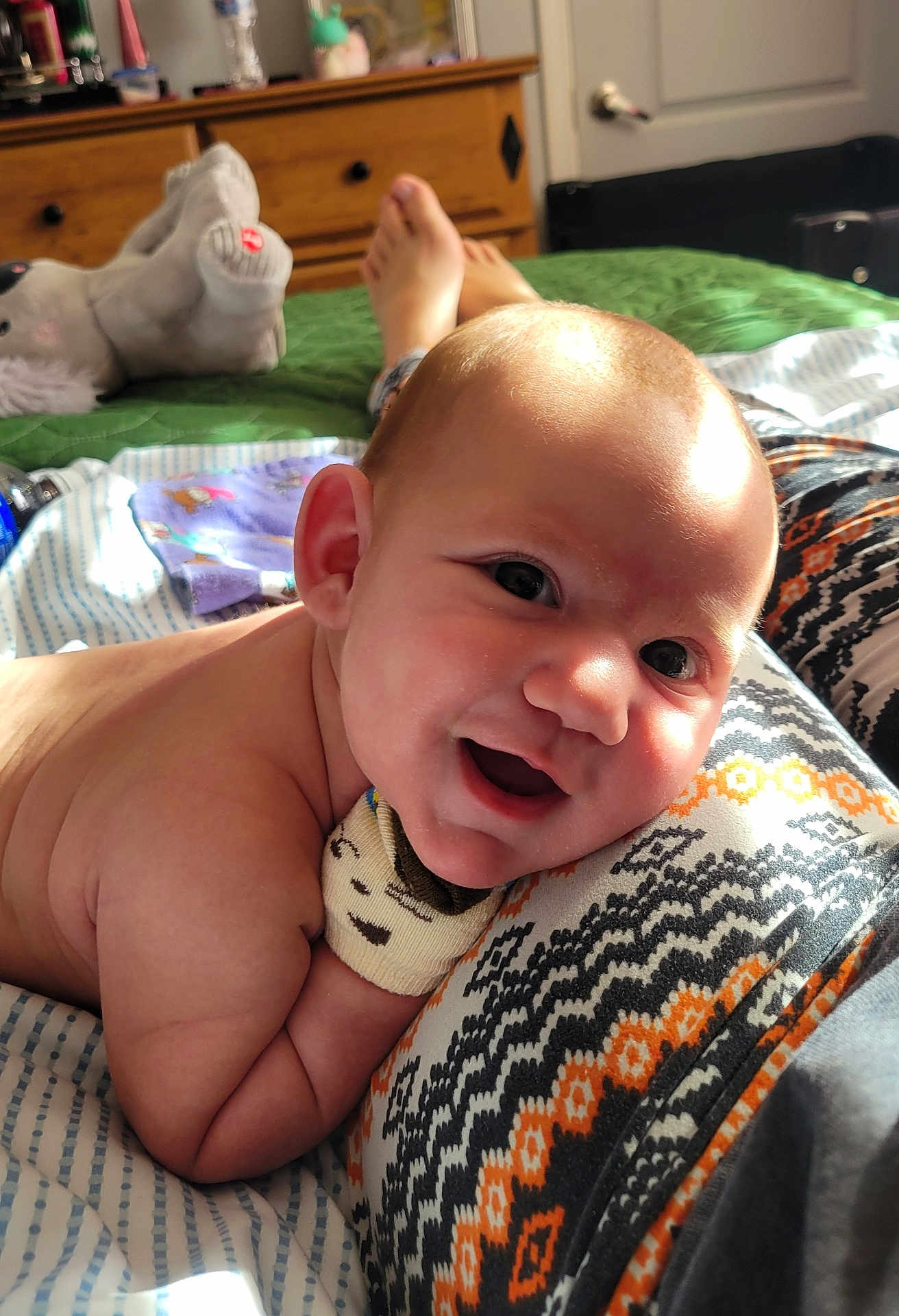 Toji joined the competition — help win amazing prizes! baby, smiling, happy, infant, blanket, patterned_clothing, indoor, bedroom, soft_toy, wooden_furniture, natural_light, face, skin, head, cute, child, person, lying_down, cozy, warm