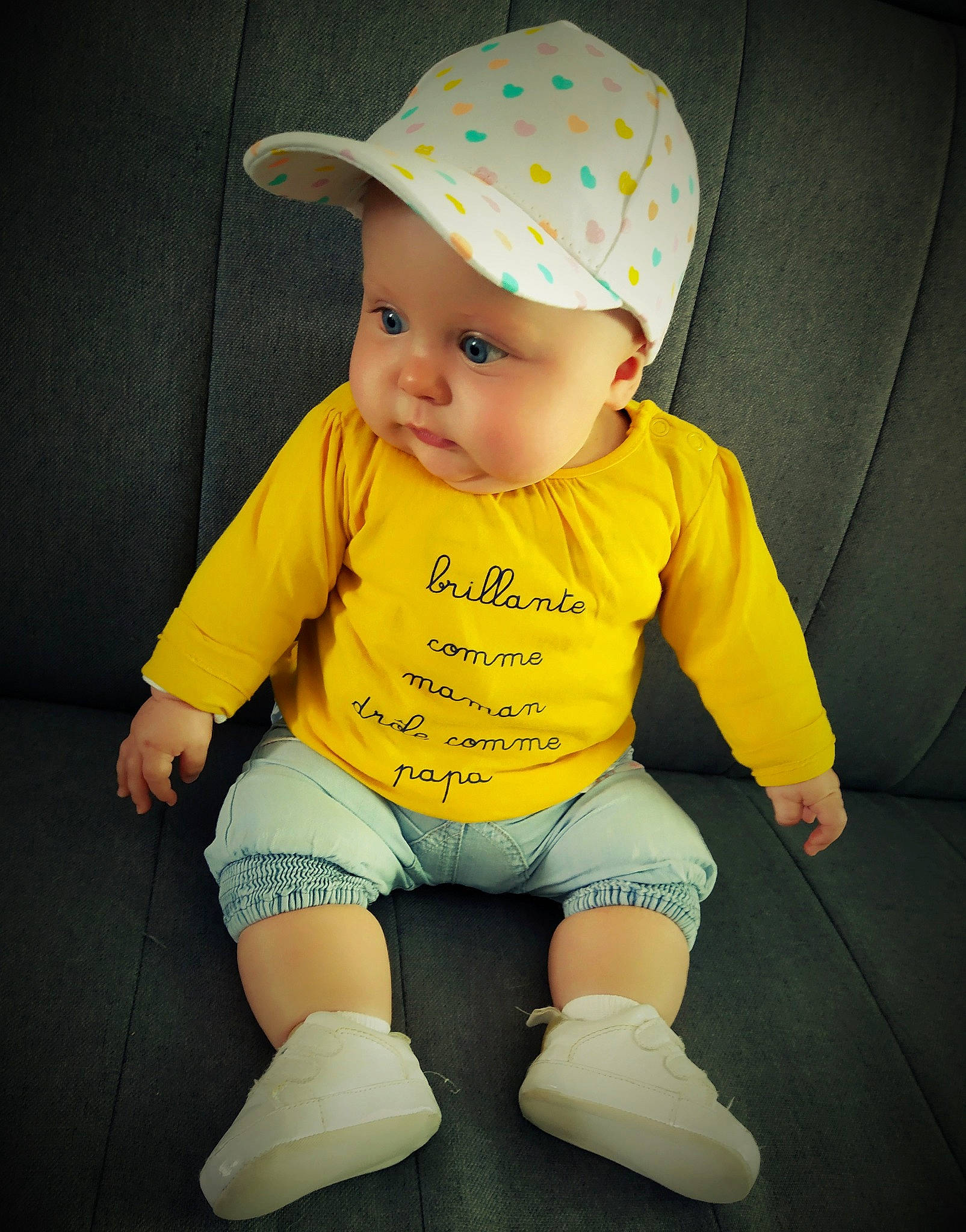 Mya participe au concours pour gagner de l'argent avec cette photo : baby, baby_products, baby_toddler_clothing, child, fashion_accessory, hat, headgear, headwear, person, product, skin, toddler, yellow