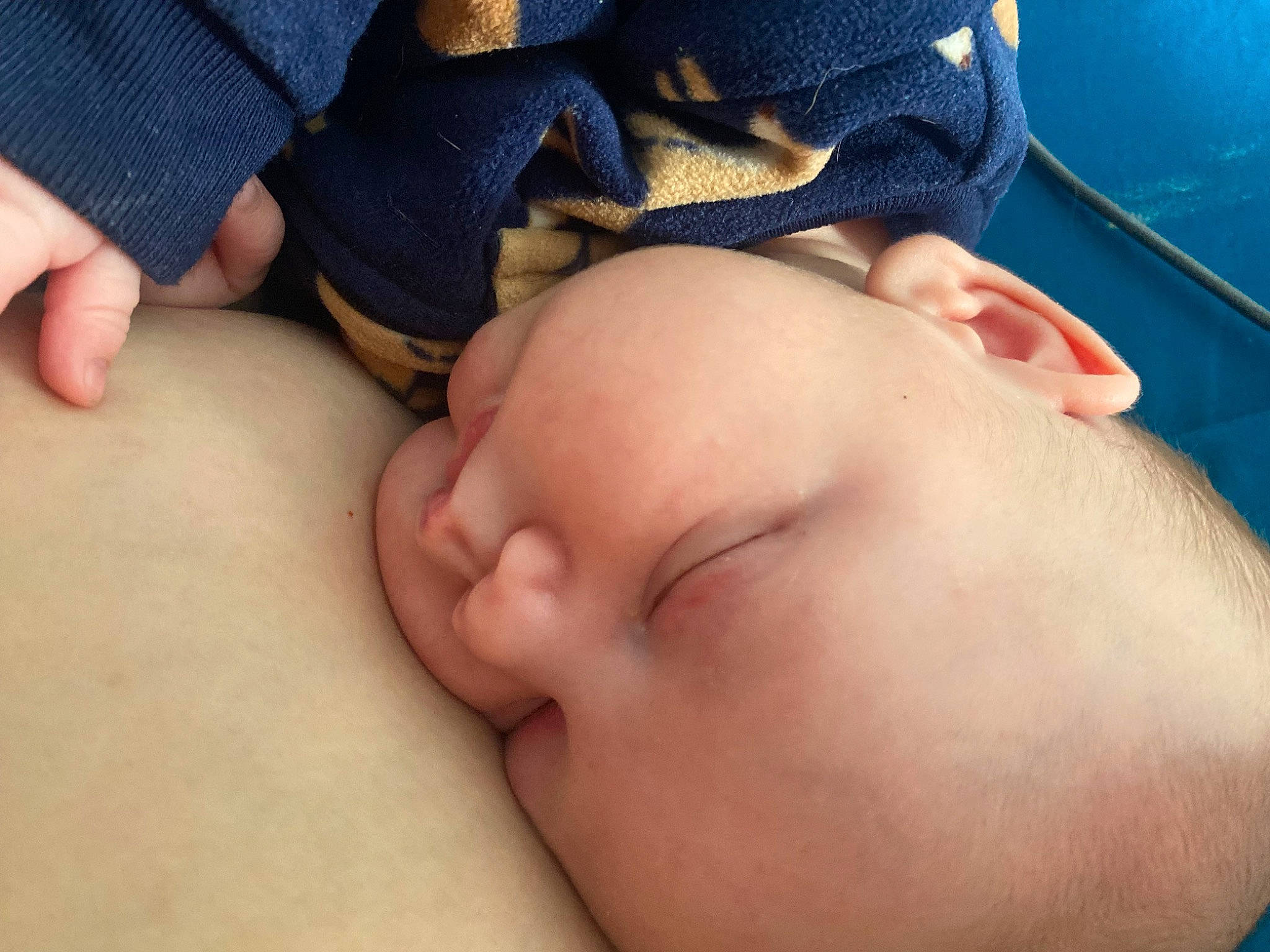 Charlie is registered to the contest to win money with this photo: abdomen, baby, blue, cheek, child, comfort, electric_blue, eyelash, finger, foot, gesture, human_body, mouth, muscle, nail, neck, nose, person, skin, thumb