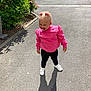 toddler, child, pacifier, pink_sweatshirt, black_leggings, white_shoes, hair_bows, shadow, sunlight, pavement, outdoor, greenery, flowers, sidewalk, curb, casual_clothing, standing, cute, happy, daytime