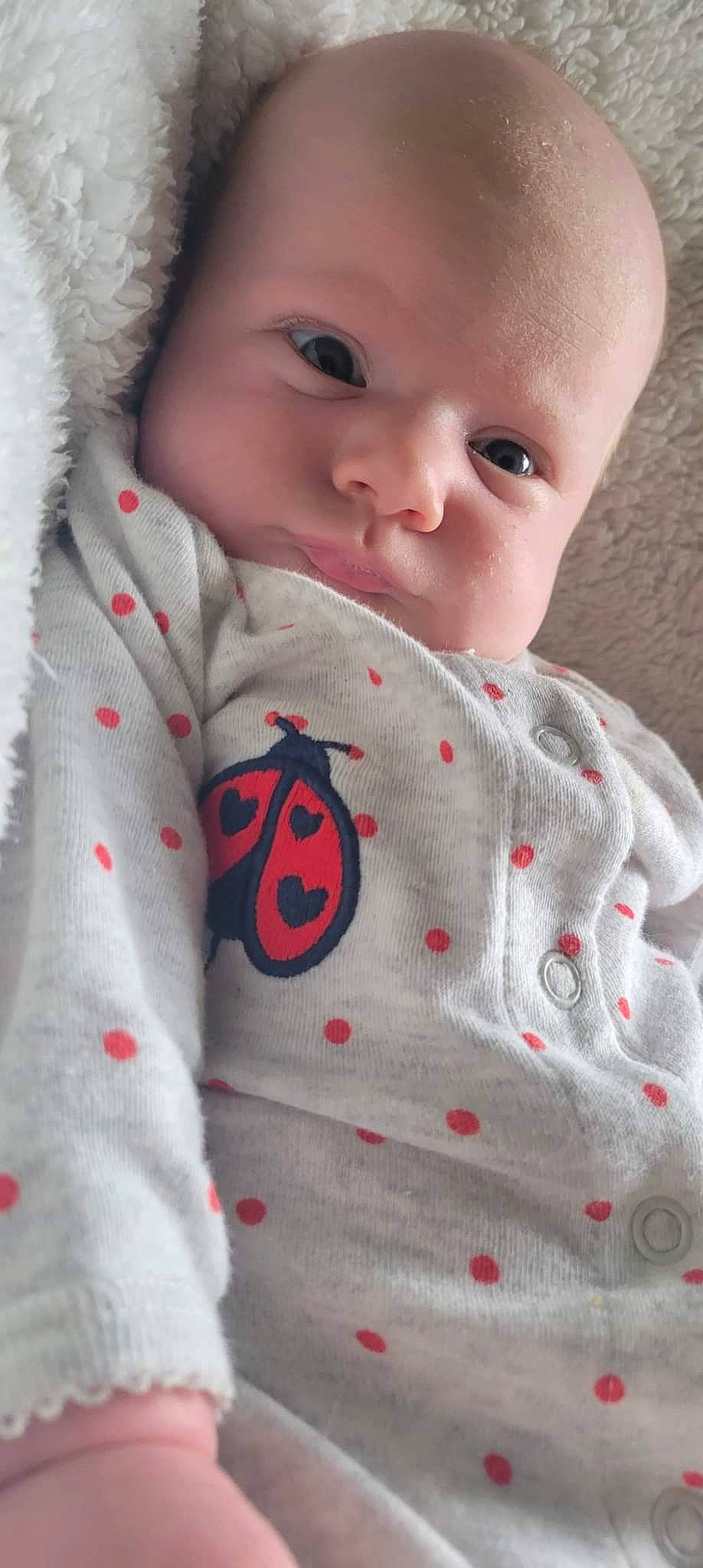 Ayla is registered to the contest to win money with this photo: baby, baby_toddler_clothing, cheek, child, collar, comfort, eyelash, face, happy, human_body, linens, lip, neck, nose, pattern, person, skin, sleeve, smile, textile