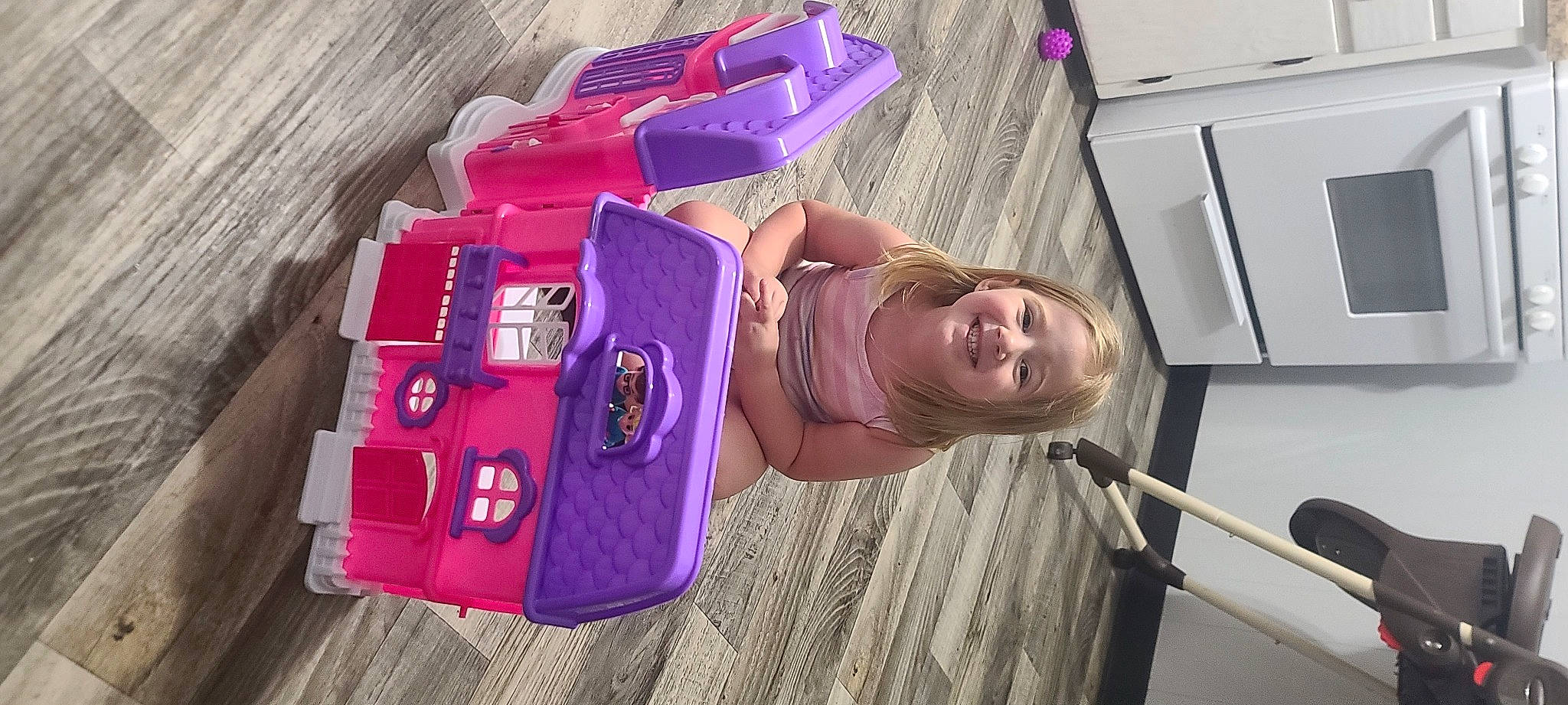 Paisley is registered to the contest to win money with this photo: baby_products, bag, child, flooring, fun, happy, joy, leisure, luggage_and_bags, magenta, person, pink, purple, room, smile, t_shirt, toddler, travel, vacation, vehicle_door