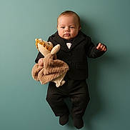 Kingston joined the competition — help win amazing prizes! baby, infant, child, portrait, suit, bow_tie, stuffed_animal, plush_toy, teal_background, studio_lighting, lying_down, cute, adorable, formalwear, one_person, small_hands, soft_texture, neutral_expression, fashionable, toy_holder