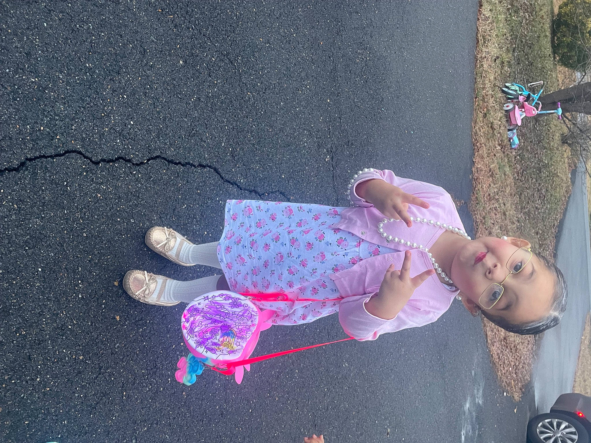 Elani is registered to the contest to win money with this photo: asphalt, baby, child, concrete, costume, dress, fun, leisure, magenta, pattern, person, pink, plant, road_surface, shadow, sidewalk, toddler, toy, tree, visual_arts