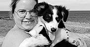Baya a rejoint le concours — aidez-le/la à gagner de superbes lots ! woman, person, puppy, dog, pet, animal, hugging, smiling, portrait, black_and_white, beach, seaside, ocean, shoreline, sand, outdoor, glasses, tattoo, collar, tongue