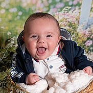 Jules a rejoint le concours — aidez-le/la à gagner de superbes lots ! baby, basket, blanket, blue_hoodie, clothing, cute, face, floral_background, happy, infant, indoors, light, person, portrait, smile, soft_texture, white_polo, wooden_basket, young_child, greenery