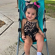 Jayselina joined the competition — help win amazing prizes! toddler, child, smiling, stroller, outdoor, sidewalk, leopard_print, hair_bows, white_socks, happy, cute, seatbelt, greenery, concrete, playful, young_child, portrait, baby, casual, sunlight