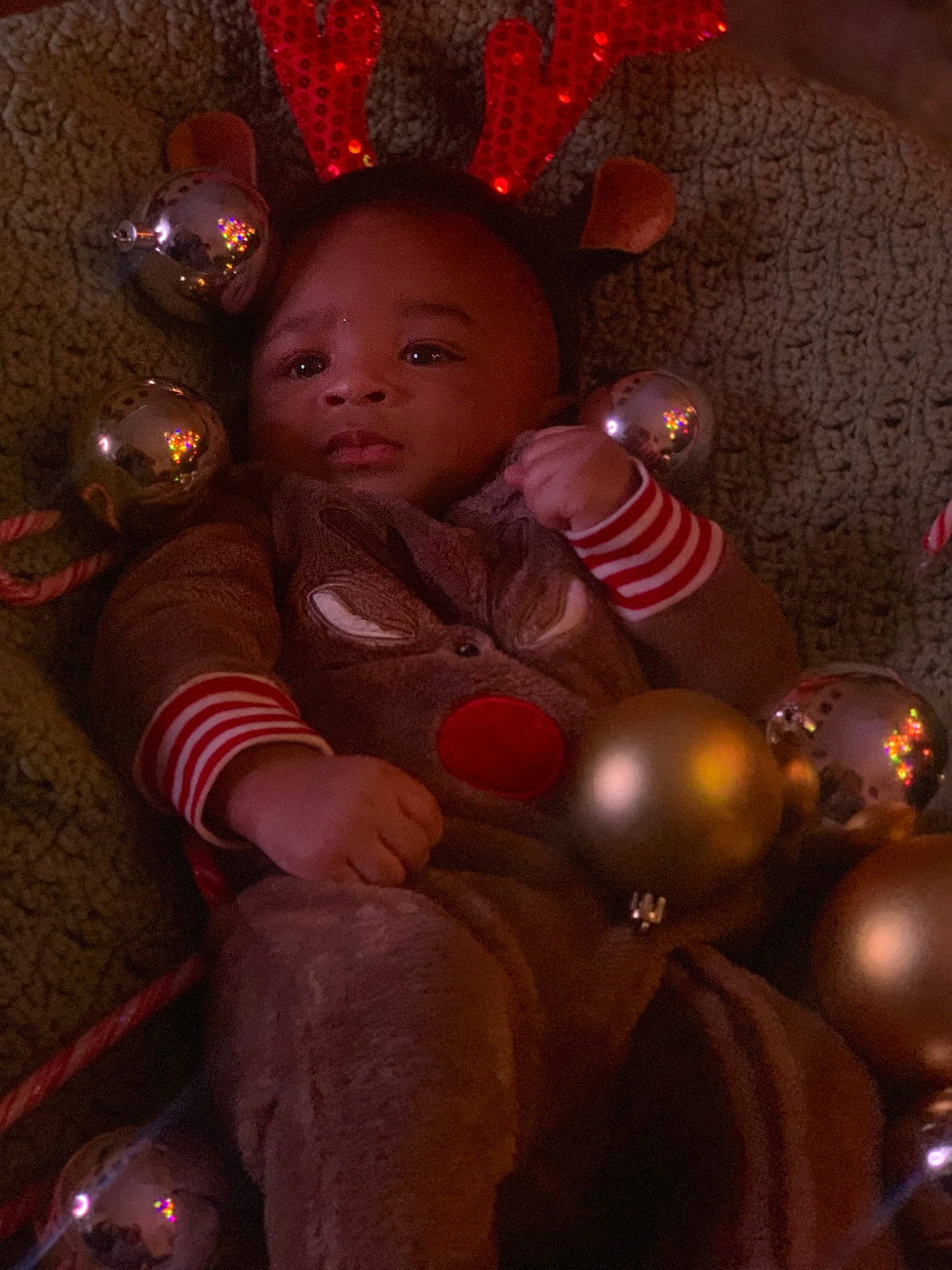 Sekani is registered to the contest to win money with this photo: baby, child, christmas, christmas_decoration, christmas_eve, christmas_ornament, darkness, event, fun, happy, holiday, holiday_ornament, lap, light, lighting, ornament, person, pink, red, toddler