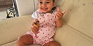 Kamélya participe au concours pour gagner de l'argent avec cette photo : apparel, child, clothing, couch, cute, foot, furniture, hair, hand, happy, ice_cream, indoor, infant, living_room, person, playful, relaxed, seat, smiling, toddler