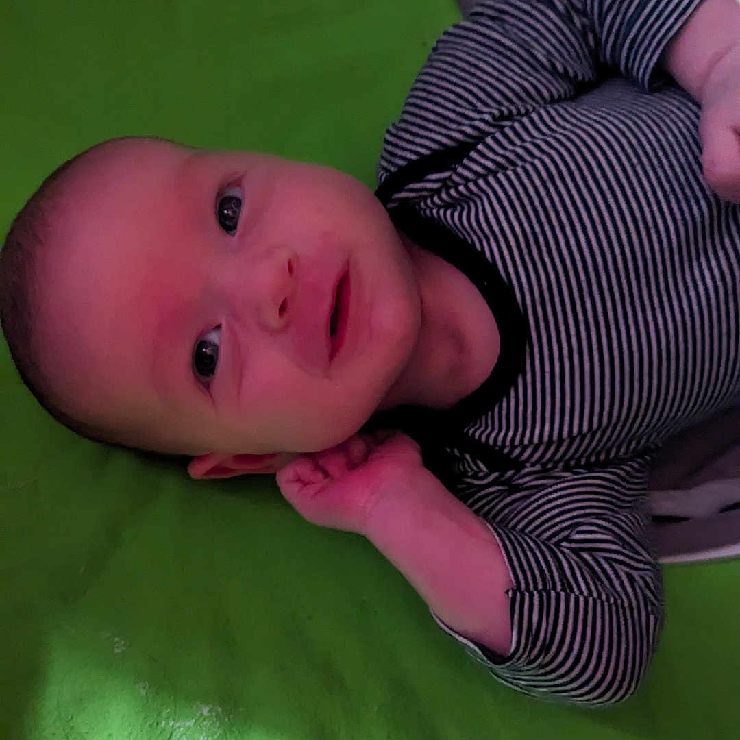 Axel is registered to the contest to win money with this photo: baby, bodypart, clothing, crib, face, finger, furniture, hand, happy, hat, head, infantbed, longsleeve, newborn, pattern, person, photography, portrait, sleeve, smile