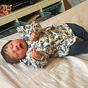 Lison participe au concours pour gagner de l'argent avec cette photo : baby, sleeping, bed, clothing, floral, pants, socks, face, hand, indoor, room, storage, toy, blanket, furniture, person, infant, cute, rest, peaceful