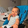 baby, child, infant, smiling, happy, portrait, indoors, living_room, chair, blue_chair, seated, striped_shirt, light_clothing, short_hair, face, eyes, fist, armrest, furniture, home