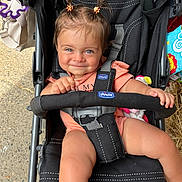 Lina a rejoint le concours — aidez-le/la à gagner de superbes lots ! baby, toddler, stroller, child, smile, pigtails, outdoor, toy, clothing, seatbelt, hand, face, blue_eyes, fabric, playful, cute, person, sitting, expression, chicco