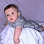 baby, infant, child, striped_clothing, blanket, white_blanket, lying_down, curious, blue_eyes, soft_background, indoor, portrait, cute, young_child, baby_pose, infant_clothing, baby_skin, head, face, expression