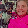 Kova is registered to the contest to win money with this photo: person, dog, smile, pink_shirt, harness, collar, vehicle_interior, seat, window, jeans, earrings, short_hair, nose_piercing, happy, pet, companion, casual, indoor, portrait, friendship