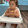 baby, birthday, cake, celebration, child, curious, curly_hair, face, flooring, food, hands, high_chair, indoor, messy, party, skin, socks, table, toddler, toy