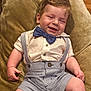 baby, child, smiling, bow_tie, suspenders, white_shirt, striped_shorts, plush_chair, indoor, happy, cute, portrait, infant, dressed_up, clothing, person, head, face, skin, sitting