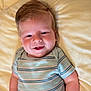 baby, infant, smile, cheeks, onesie, striped_clothing, lying_down, blanket, soft_texture, happy, child, cute, portrait, skin, hair, face, young, indoors, person, toddler