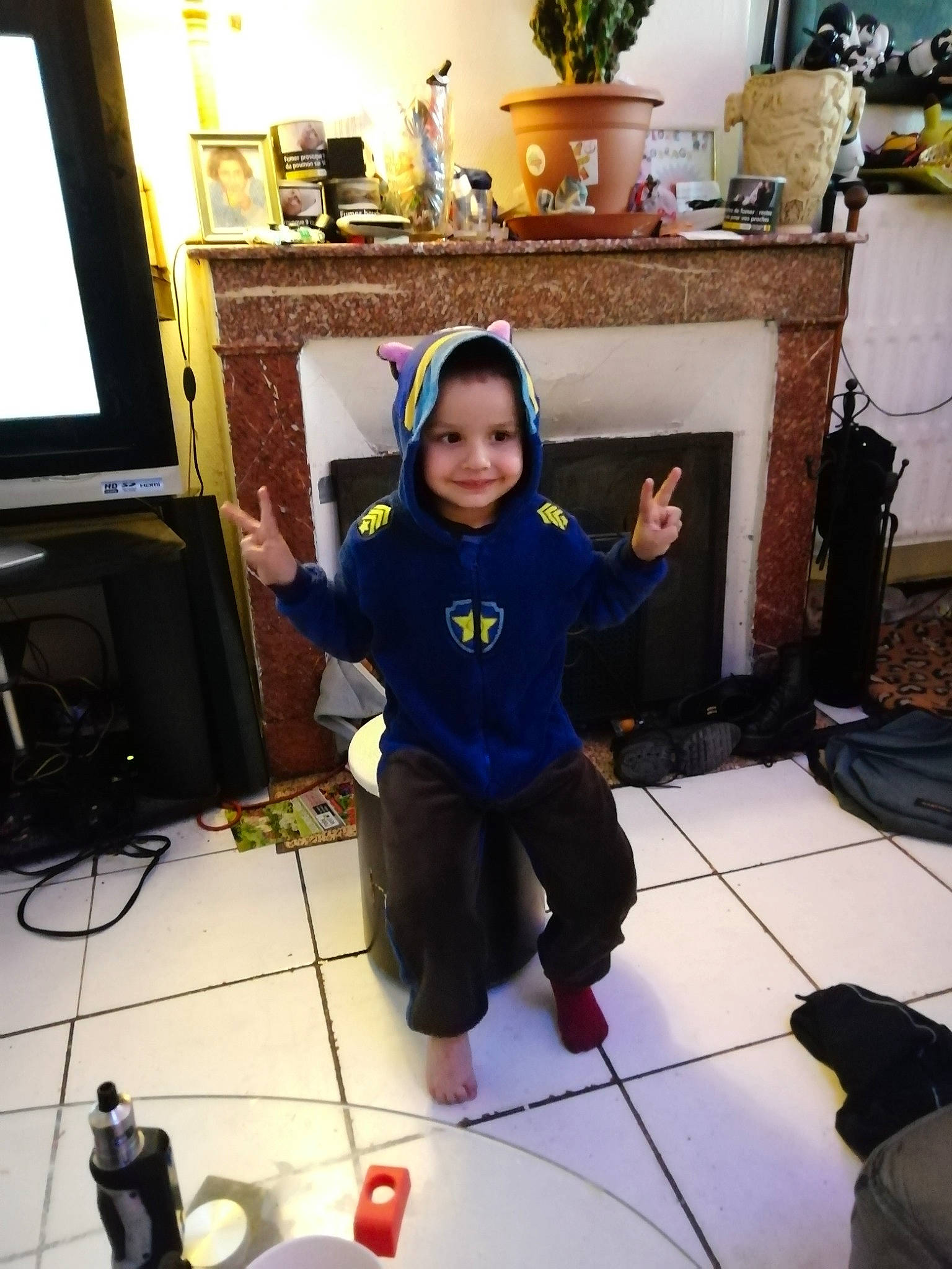 Aaron participe au concours pour gagner de l'argent avec cette photo : audio_equipment, black, child, computer_monitor, display_device, floor, flooring, fun, headwear, home_appliance, house, houseplant, joy, living_room, person, plant, play, room, smile, television