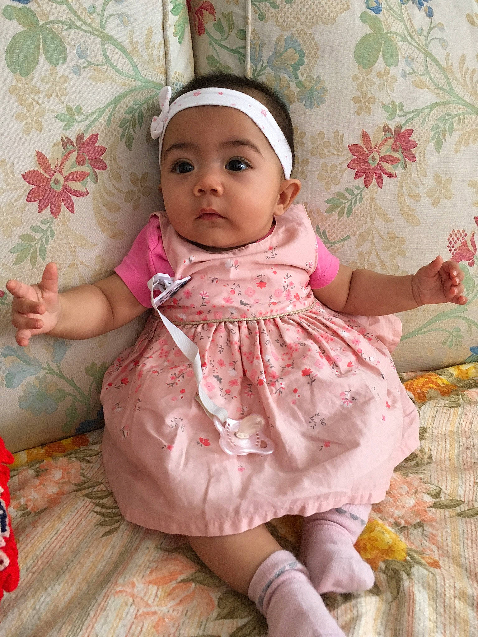 Linda participe au concours pour gagner de l'argent avec cette photo : baby, baby_products, baby_toddler_clothing, cheek, child, day_dress, dress, embellishment, eye, happy, headwear, iris, magenta, pattern, person, pink, ruffle, sitting, skin, sleeve