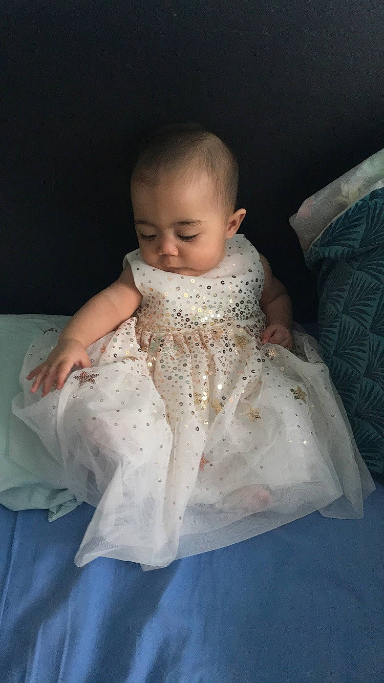 Linda participe au concours pour gagner de l'argent avec cette photo : abdomen, arm, baby, baby_toddler_clothing, cheek, comfort, dress, embellishment, eye, flash_photography, hand, happy, head, human_body, iris, lip, person, skin, sleeve, toddler