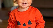 Eliza is registered to the contest to win money with this photo: toddler, child, baby, smiling, portrait, indoors, orange_clothing, pumpkin_costume, halloween, hair_clip, brown_hair, standing, happy, face, hands, long_sleeves, cozy, home, blurred_background, photography