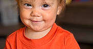 Eliza is registered to the contest to win money with this photo: baby, child, close_up, clothing, cute, eyes, face, hair, hair_bow, halloween, happy, indoor, orange_shirt, photography, playful, portrait, pumpkin, sitting, smiling, toddler