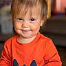 Eliza is registered to the contest to win money with this photo: baby, child, toddler, portrait, smiling, happy, face, eyes, hair, hair_bow, orange_shirt, pumpkin, halloween, clothing, indoor, close_up, sitting, playful, cute, photography