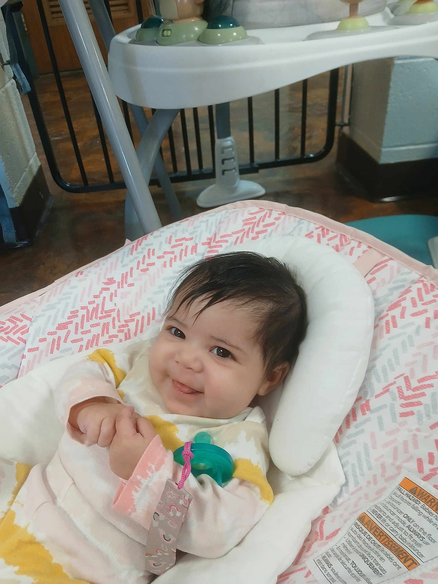 Serenity is registered to the contest to win money with this photo: baby, infant, smiling, pacifier, baby_seat, indoor, child, cute, clothing, playful, person, comfort, toy, happy, head_support, patterned_fabric, young_child, hands, face, relaxing