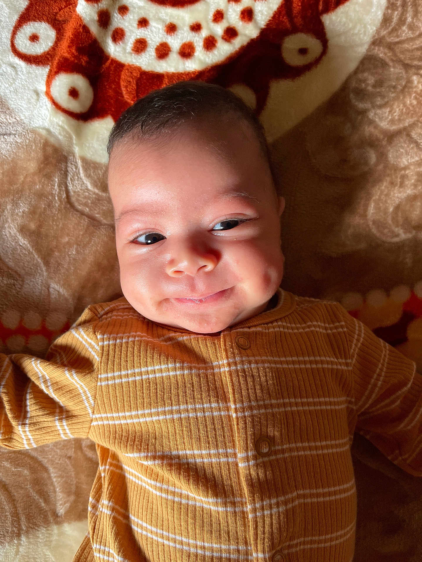 Haroon joined the competition — help win amazing prizes! baby, infant, smiling, face, eyes, clothing, striped, yellow, blanket, patterned, cozy, lying_down, cute, portrait, happy, child, indoor, soft_lighting, skin, expression