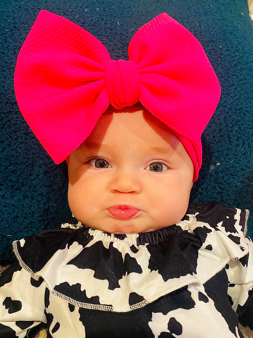 Molly Grace is registered to the contest to win money with this photo: art, baby, baby_toddler_clothing, cap, chin, costume_hat, face, font, happy, hat, head, headgear, headpiece, headwear, lip, magenta, pattern, person, pink, sleeve