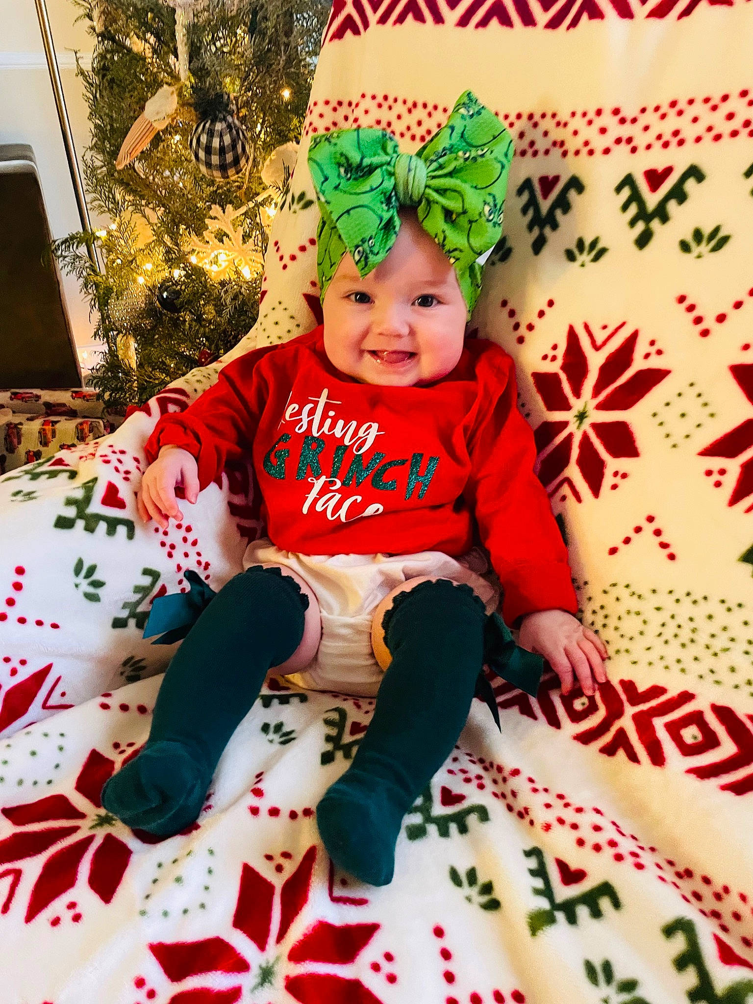 Molly Grace is registered to the contest to win money with this photo: baby, baby_toddler_clothing, child, christmas, christmas_decoration, christmas_eve, christmas_ornament, costume_hat, event, face, fictional_character, fun, happy, headwear, holiday, joy, lap, pattern, person, room