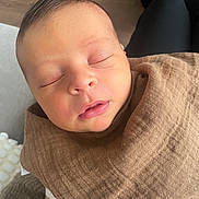 Zack participe au concours pour gagner de l'argent avec cette photo : newborn, baby, sleeping, face, person, brown_cloth, cozy, indoor, human, infant, closeup, peaceful, resting, legs, lap, blanket, soft, skin, head, comfort