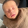 newborn, baby, sleeping, face, person, brown_cloth, cozy, indoor, human, infant, closeup, peaceful, resting, legs, lap, blanket, soft, skin, head, comfort