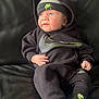 baby, infant, black_clothing, nike, hoodie, hat, socks, couch, leather, blue_eyes, cute, portrait, indoor, child, small_hand, sitting, looking_away, cozy, casual, comfortable