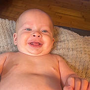 Kannan joined the competition — help win amazing prizes! baby, infant, smiling, bare_chest, diaper, blanket, wooden_floor, indoor, portrait, happy, face, head, eyes, tongue, smile, belly_button, hand, skin, lying_down, cozy