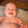 baby, infant, smiling, bare_chest, diaper, blanket, wooden_floor, indoor, portrait, happy, face, head, eyes, tongue, smile, belly_button, hand, skin, lying_down, cozy