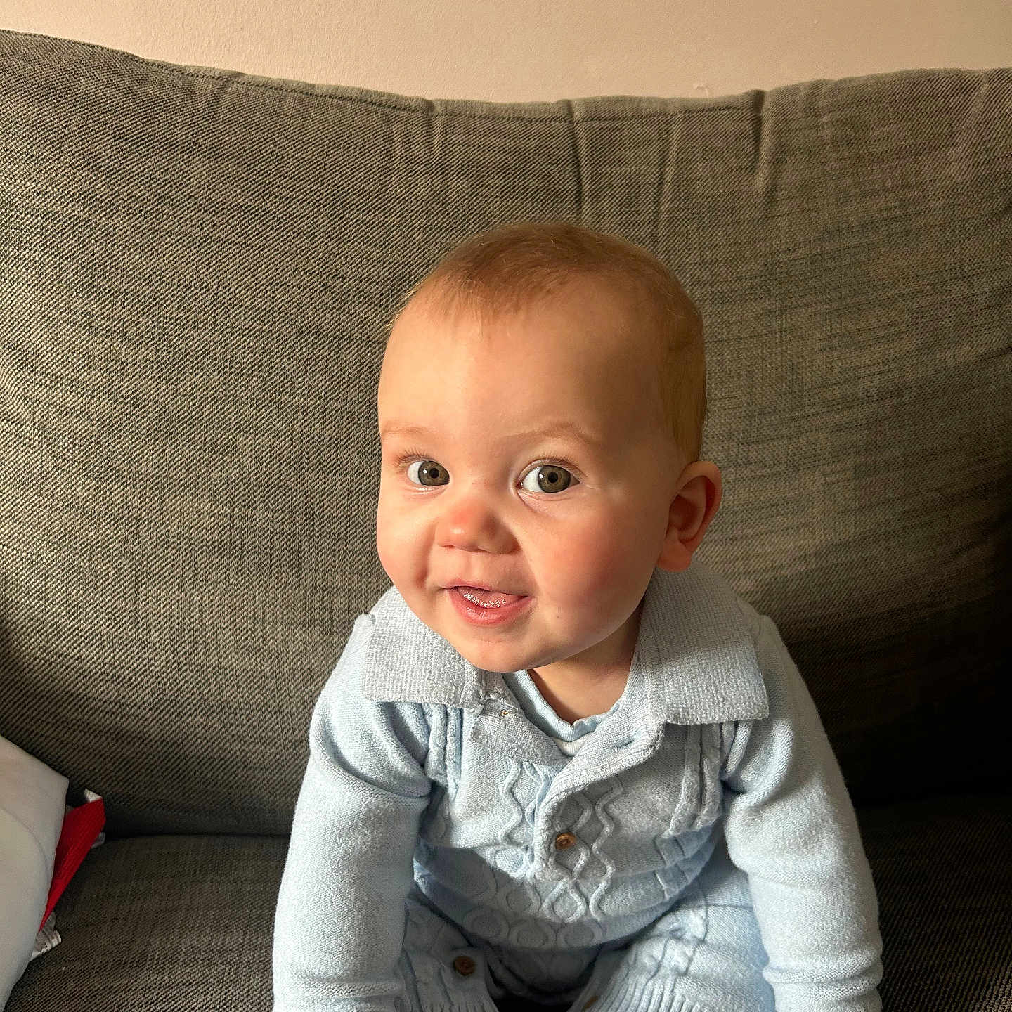 George is registered to the contest to win money with this photo: baby, bodypart, clothing, couch, crawling, cushion, face, finger, furniture, hand, happy, head, homedecor, knitwear, pants, person, photography, portrait, sitting, sweater