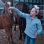 Emie a rejoint le concours — aidez-le/la à gagner de superbes lots ! child, girl, foal, horse, animal, petting, stable, barn, headband, jeans, sneakers, dirt, outdoor, farm, young, curious, fence, animal_care, daylight, casual_clothing