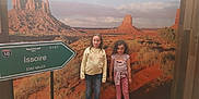 Cléa participe au concours pour gagner de l'argent avec cette photo : child, children, girls, portrait, indoor, mural, desert, rock_formation, road_sign, casual_clothing, scenery, nature, landscape, jeans, long_sleeves, curly_hair, standing, smiling, photography, tourist_spot