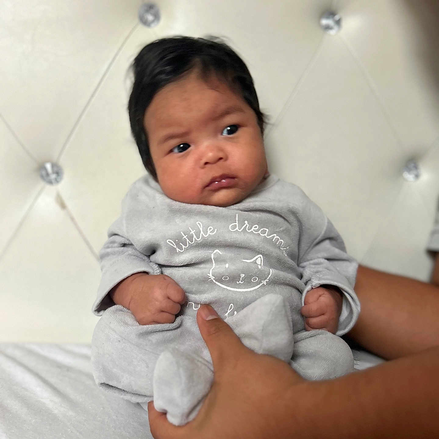 Mickaëlla a rejoint le concours — aidez-le/la à gagner de superbes lots ! baby, bed, cat_drawing, child, clothing, cushion, cute, expression, grey_outfit, hand, headboard, holding, indoor, infant, person, portrait, seated, skin, soft_surface, young