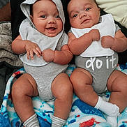 Twins joined the competition — help win amazing prizes! baby, baby_bib, baby_onesie, bib, blanket, chubby, closeup, clothing, cute, face, happy, hood, indoor, infant, person, sitting, smiling, socks, toddler, two_babies