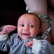 Ayla is registered to the contest to win money with this photo: baby, smiling, infant, clothing, onesie, hand, face, eyes, arm, wristband, text, happy, person, skin, portrait, indoor, cute, child, young, expression